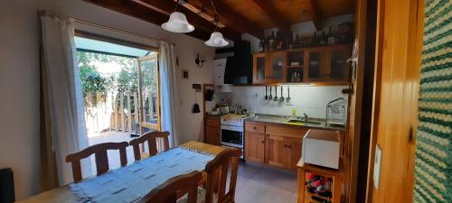 a kitchen with a wooden table and a table and a table and a dining room at Cabaña Centrica Maiten II in San Martín de los Andes