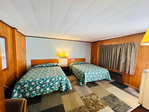 a hotel room with two beds and a window at Sun N Snow Hotel in Cadillac