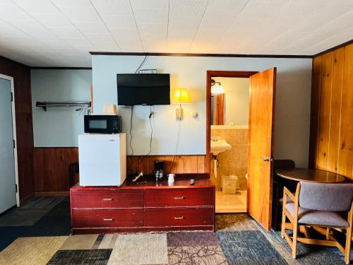 a room with a tv on top of a dresser at Sun N Snow Hotel in Cadillac