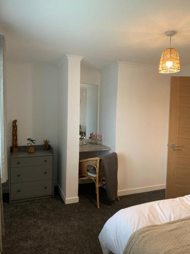 a bedroom with a desk and a dresser with a mirror at Dumfries Apartment 2 in Dumfries