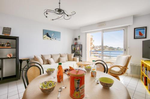 un salon avec une table et un canapé dans l'établissement Vue mer à 50m plage - Appartement pour 4, à Erquy