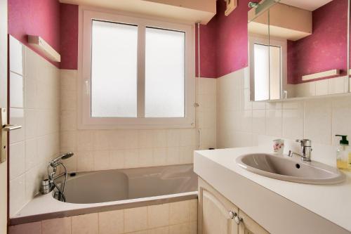 a bathroom with a tub and a sink and a mirror at Vue mer à 50m plage - Appartement pour 4 in Erquy