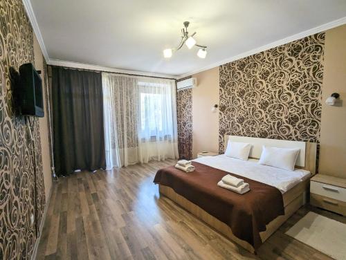 a bedroom with a bed with two towels on it at HISTORICAL OLD CITY Apartament, Старе місто , 2 спальні, балкон-тераса, 85 кв м in Kamianets-Podilskyi