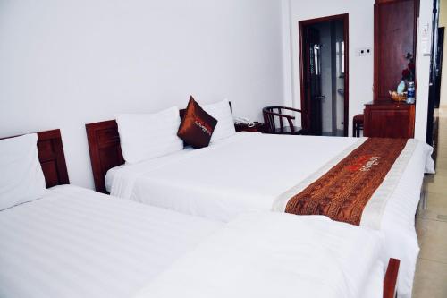 two beds sitting next to each other in a bedroom at Quốc Khánh Hotel Da Nang in Da Nang