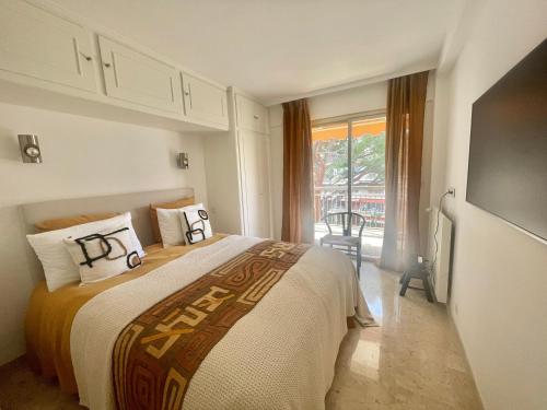 une chambre avec un lit et une grande fenêtre dans l'établissement Appartement moderne 1 chambre, à Cannes