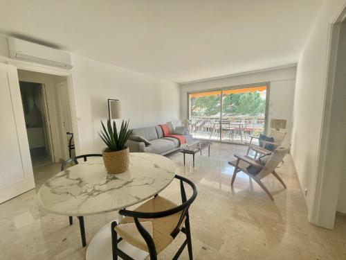 un salon avec une table, des chaises et un canapé dans l'établissement Appartement moderne 1 chambre, à Cannes