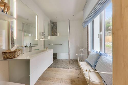 une salle de bain avec un lavabo, un miroir et un canapé dans l'établissement Maison pour 8 - Piscine - 550 m de la plage, à Saint-Pierre-Quiberon
