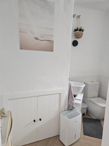 uma casa de banho branca com um WC e um lavatório em Casa Isis Garden em Matalascañas