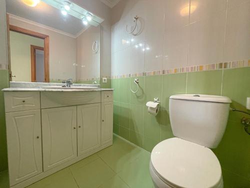 a bathroom with a toilet and a sink and a mirror at Apartamentos Portofino 3000 in Oropesa del Mar
