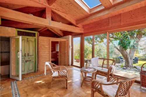 - une véranda avec des chaises et une table dans l'établissement 700m de la plage, maison pour 12- Sauna et hammam, à Penmarcʼh