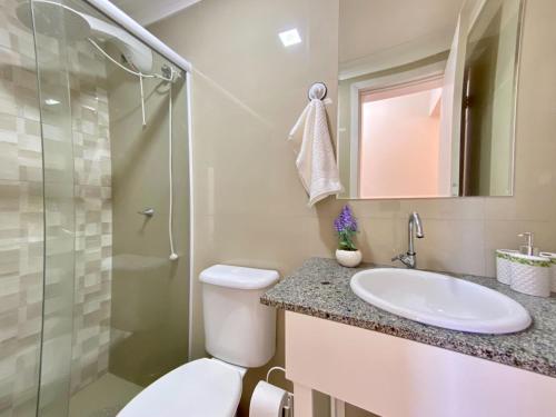 a bathroom with a toilet and a sink and a shower at Resid. Clube Mar Grosso - Laguna - LAG605 in Laguna