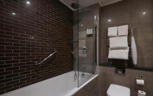La salle de bains est pourvue d'une douche, d'un lavabo et de toilettes. dans l'établissement Cameron House - Lodge 17 - Loch Lomond, à Balloch