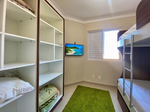 a bedroom with bunk beds and a green rug at Resid. Clube Mar Grosso - Laguna - LAG605 in Laguna