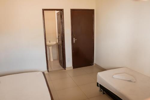 ein kleines Zimmer mit einem Bett und einem Spiegel in der Unterkunft Quartos no centro de Três Marias in Três Marias
