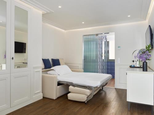 a hospital room with a bed and a couch at H10 Universitat in Barcelona