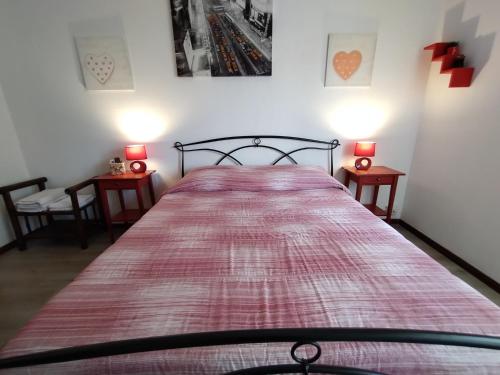 1 dormitorio con 1 cama grande, 2 mesas y 2 lámparas en Damarilù, en Alghero