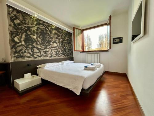 ein Schlafzimmer mit einem Bett und einem Wandgemälde in der Unterkunft Kibilù - Ospedale Galeazzi - Rho Fiera - Milano in Arese