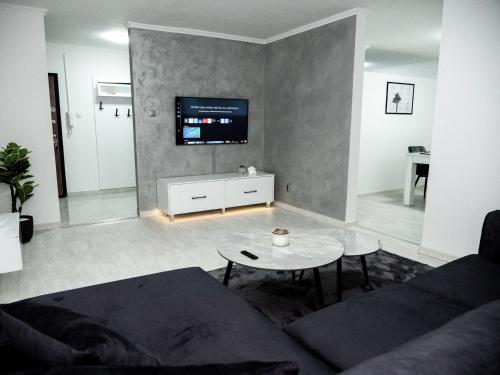 a living room with a couch and a table at Apartman PLATINUM in Doboj