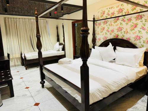 a bedroom with a four poster bed with white pillows at Hotel Jaipur Dreams in Jaipur