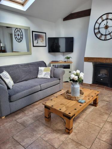 a living room with a couch and a coffee table at Barn Owl in Happisburgh