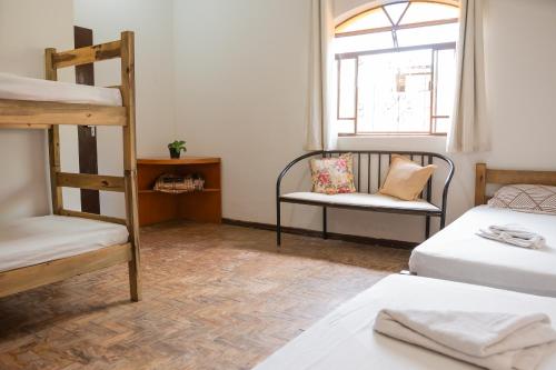 Zimmer mit 2 Etagenbetten und einem Stuhl in der Unterkunft Quartos no centro de Três Marias in Três Marias