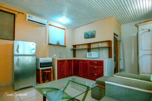a kitchen with a refrigerator and a glass table at 6 Cute studio, GREAT location, close to beach! With AC! in Carrillo