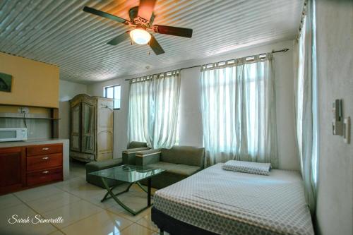 1 dormitorio con 1 cama y ventilador de techo en 6 Cute studio, GREAT location, close to beach! With AC!, en Carrillo