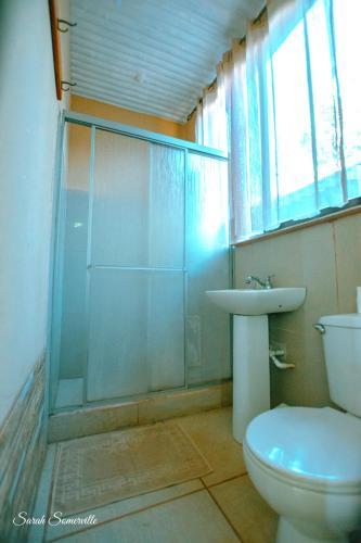 a bathroom with a shower and a toilet and a sink at 6 Cute studio, GREAT location, close to beach! With AC! in Carrillo
