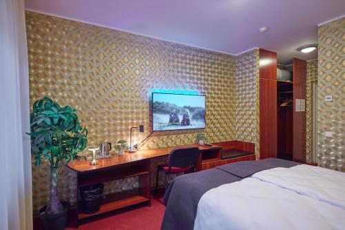 a hotel room with a bed and a desk with a computer at SPA Hotell Peetrimõisa Villa in Viljandi