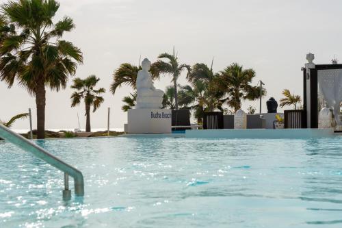a swimming pool with palm trees in the background at Hotel LIVVO Budha Beach in Santa Maria