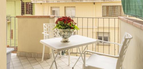 a vase of flowers sitting on a table on a balcony at Leandro's House Near Thermal Baths in Montecatini Terme
