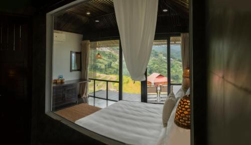 a bedroom with a bed and a view of a balcony at Black Ship Sapa in Sapa