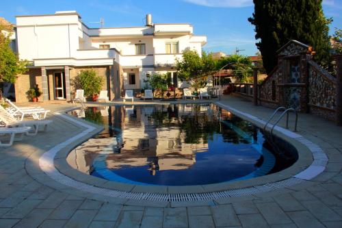 a swimming pool in front of a building with a house at Hotel Dimitra Sun in Archangelos