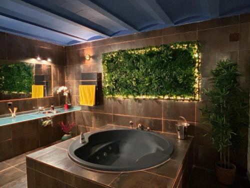 La salle de bains est pourvue d'une grande baignoire avec un mur vert. dans l'établissement Apartamento ático-dúplex en Casa Rural Fundanal en Hoz de Jaca, à Hoz de Jaca