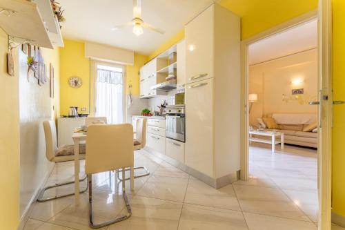 a kitchen with yellow walls and a table and chairs at Leandro's House Near Thermal Baths in Montecatini Terme