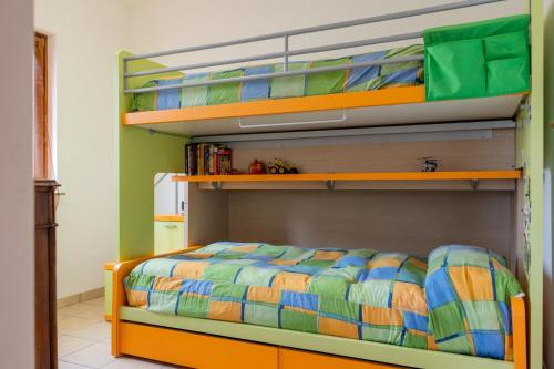 - une chambre avec des lits superposés et un couvre-lit coloré dans l'établissement Mara House, Fino del Monte Ospitar, à Fino del Monte