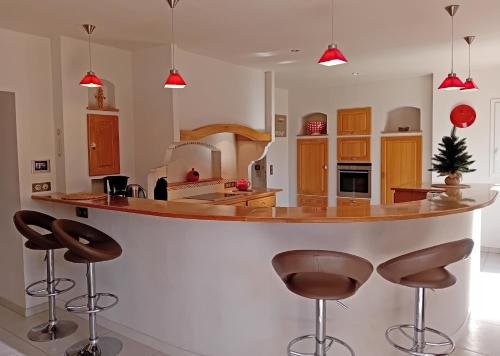 une cuisine avec un grand îlot et des tabourets de bar dans l'établissement Ti Giz Breizh - Maison bretonne sur la Vilaine, à Camoël