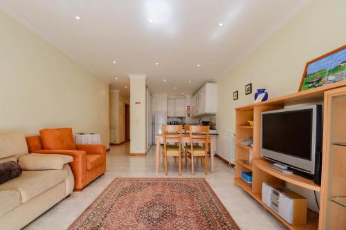 a living room with a couch and a television at Casa Coração de Viana - Near the Beach Apartment in Viana do Castelo