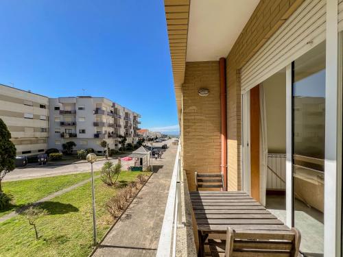 a building with benches on a sidewalk next to a street at Casa Coração de Viana - Near the Beach Apartment in Viana do Castelo