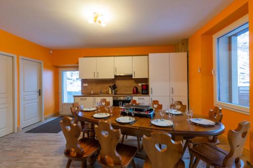 une salle à manger avec une table et des chaises et une cuisine dans l'établissement Le Bouquetin, à Entremont