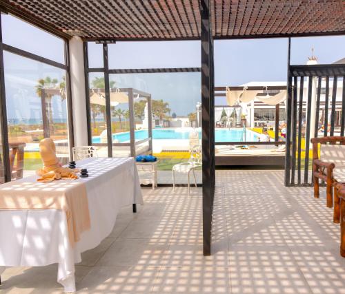 a patio with a table and a swimming pool at Hotel LIVVO Budha Beach in Santa Maria