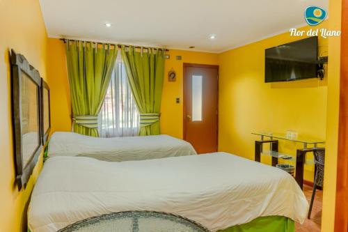 2 camas en una habitación con paredes amarillas en Complejo Deportivo y Hotelero Flor del Llano, en San Clemente