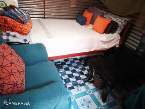 a small bed and a chair in a room at Cosy budget Single room in Nairobi