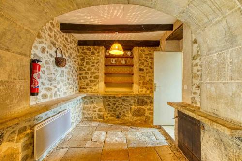 cocina con pared de piedra y extintor de incendios en Maison de l Albine, gite de groupe, en Peyrusse-le-Roc