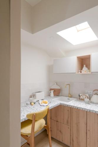 - une cuisine avec un comptoir, un évier et une table dans l'établissement Suite romantique et charmante parking, à Villeurbanne