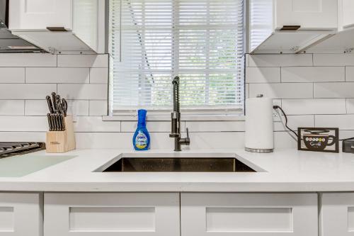 a white kitchen with a sink and a window at Cocoa Home with Large Yard 3 Mi to Indian River! in Cocoa