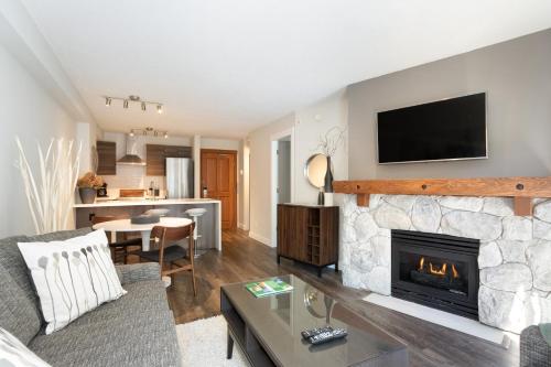a living room with a fireplace with a tv above it at Lost Lake Lodge by Whistler Premier in Whistler