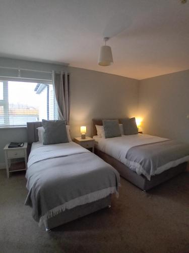 a bedroom with two beds and a window at Fairwinds Guest Accommodation in Doolin