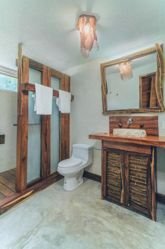 a bathroom with a toilet and a sink and a mirror at Embajada Universal By La Eufemia Group in Huay Pix