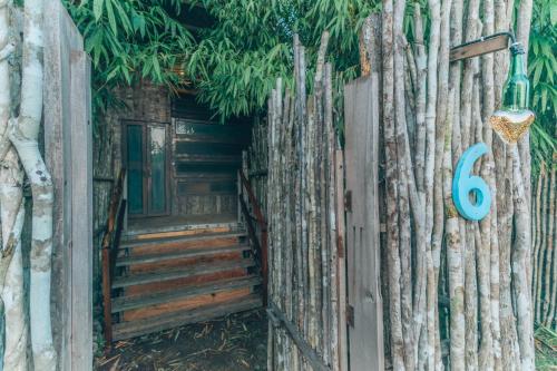 a wooden fence with a gate with a door and stairs at Embajada Universal By La Eufemia Group in Huay Pix